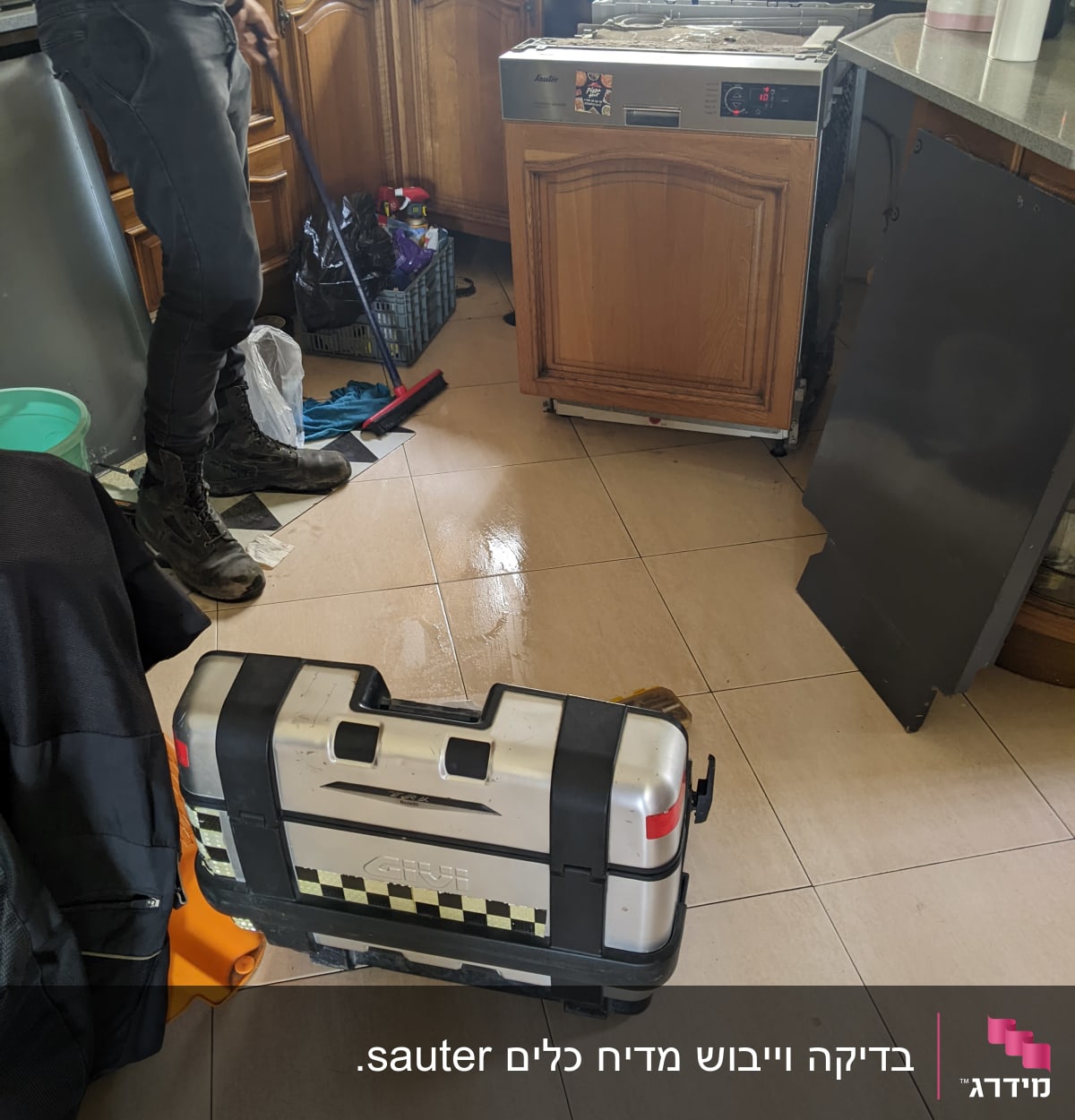 תיקון מדיח כלים במטבח עם כלי עבודה על הרצפה